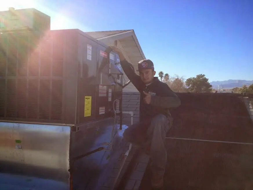 HVAC technician performing HVAC Inspection on a rooftop unit in Forsyth